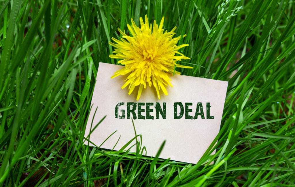 De foto laat een papier zien (dat in een grasveld ligt) waarop staat beschreven: Green deal. De Green deal ligt aan de basis van de huidige CSRD wetgeving. ARC People helpt organisaties bij het voldoen aan duurzaamheidswetgeving.